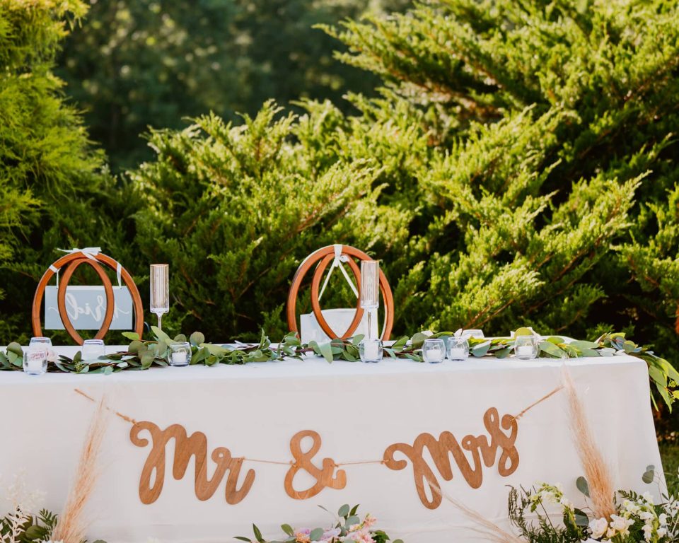 Outdoor wedding sweetheart table with flowers and mountain views at Flat Rock Farm